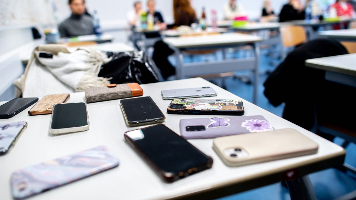 picture alliance/dpa | Hauke-Christian Dittrich (Foto: dpa Bildfunk, Handys liegen im Klassenzimmer auf dem Tisch: Neuseeland will Handys an Schulen verbieten)