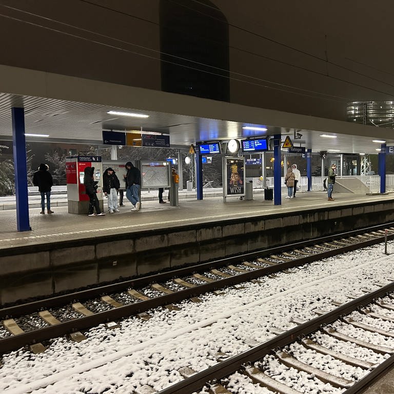 Menschen warten in der Nacht am Bahnhof Stuttgart-Vaihingen. Wegen eines Polizeieinsatzes fuhren keine S-Bahnen.