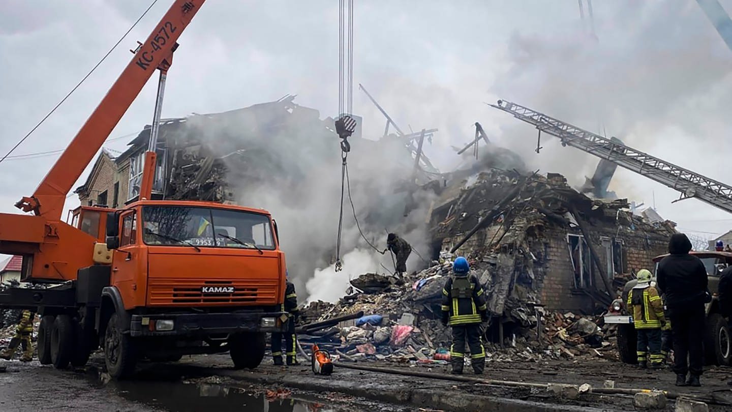 Rettungskräfte arbeiten an einem durch Beschuss beschädigten Gebäude. Forscher haben errechnet, dass durch den Ukraine-Krieg richtig viel CO2 entsteht. (Foto: dpa Bildfunk, picture alliance/dpa/Ihor Moroz, Head of the Donetsk Regional Military Administration/AP | ---)
