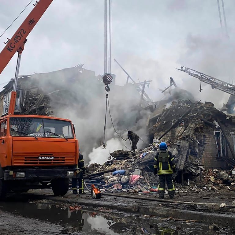 Rettungskräfte arbeiten an einem durch Beschuss beschädigten Gebäude. Forscher haben errechnet, dass durch den Ukraine-Krieg richtig viel CO2 entsteht. (Foto: dpa Bildfunk, picture alliance/dpa/Ihor Moroz, Head of the Donetsk Regional Military Administration/AP | ---)