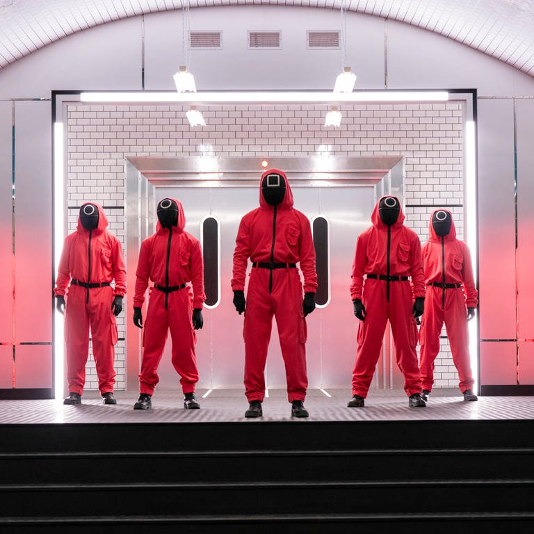 Charaktere der Serie «Squid Game: The Challenge» stehen in roten Anzügen und Masken nebeneinander. Netflix hat mitgeteilt, dass es eine zweite Staffel der Show geben wird.