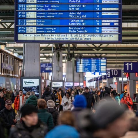 Während eine Anzeigetafel die aktuellen Abfahrten der Züge und den Hinweis auf mögliche Zugausfälle bezüglich des Sturms Zoltan anzeigt, laufen Reisende durch den Stuttgarter Hauptbahnhof. (Foto: dpa Bildfunk, picture alliance/dpa | Christoph Schmidt)