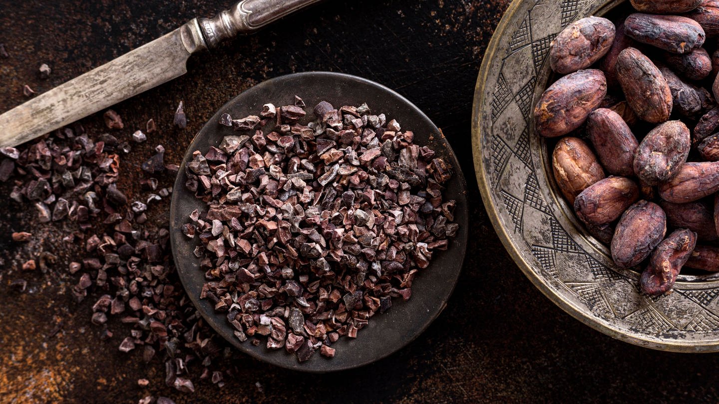 Draufsicht gemahlene Kakaobohnen Teller mit Messer Kakaobohnen (Foto: IMAGO, IMAGO / imagebroker)