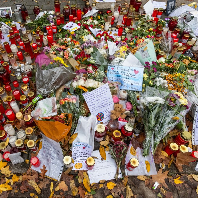 Blumen und Kerzen vor der Schule in Offenburg, in der ein 15-Jähriger von einem Mitschüler erschossen wurde. Ein Vater hatte den Täter überwältigt.