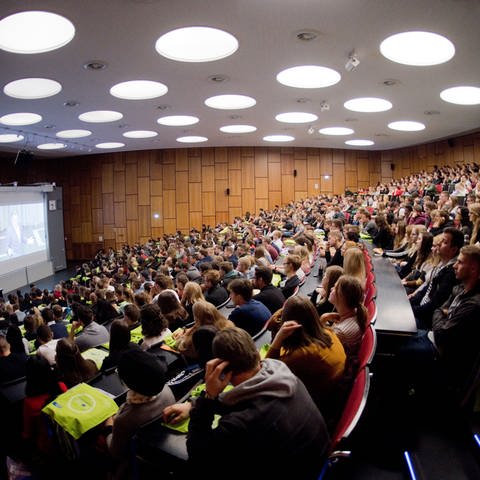 Studenten sitzen bei der Erstsemesterbegrüßung im Audimax in der Leibniz Universität.