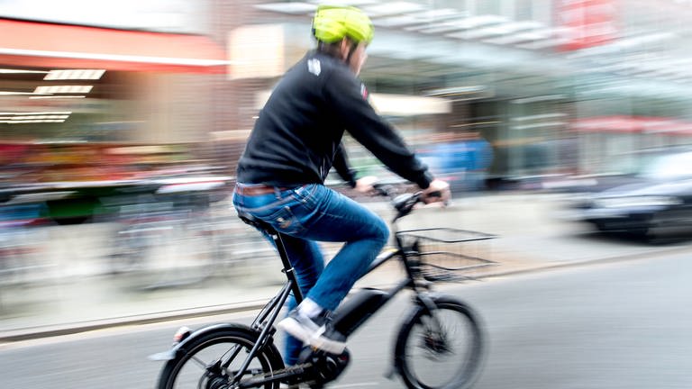 Ein Radfahrer fährt mit einem E-BikePedelec auf einer Fahrradstraße.