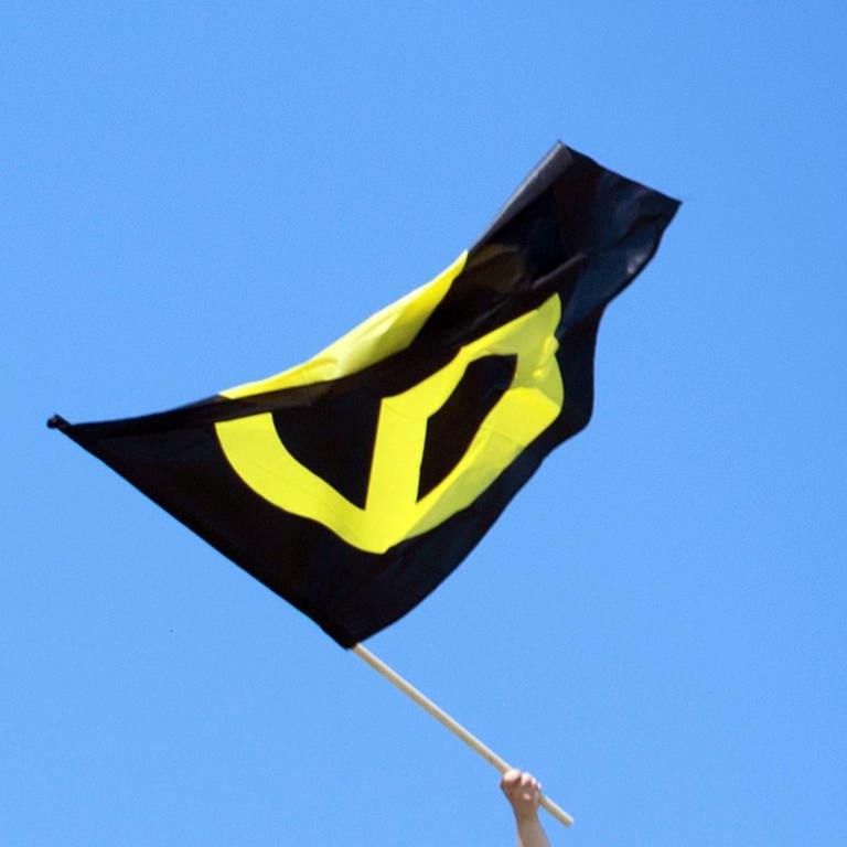 Flagge der Identitären Bewegung (schwarzgelb) (Foto: IMAGO, picture alliance/dpa | Paul Zinken)
