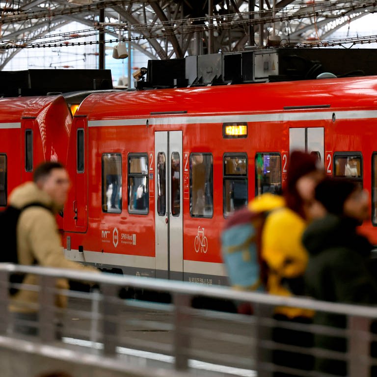 Fahrgäste vor Regionalzug am Bahnhof: Bahn-Streik wird vorzeitig beendet. Züge fahren ab Montag wieder.
