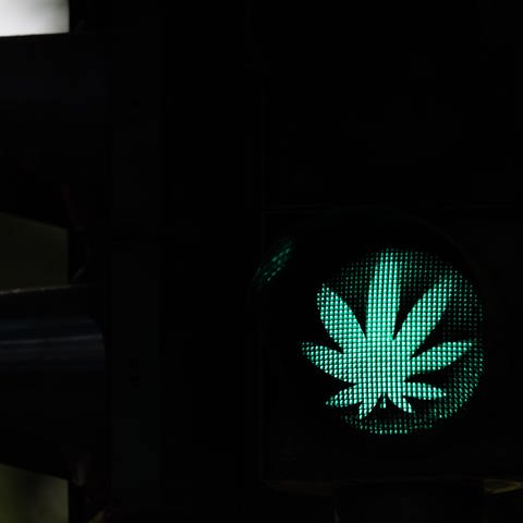 Ein Cannabis-Blatt leuchtet während der Grünphase an einer Ampel. Die Cannabis-Legalisierung in Deutschland kann kommen. Jetzt müssen noch Bundesrat und Bundestag zustimmen.