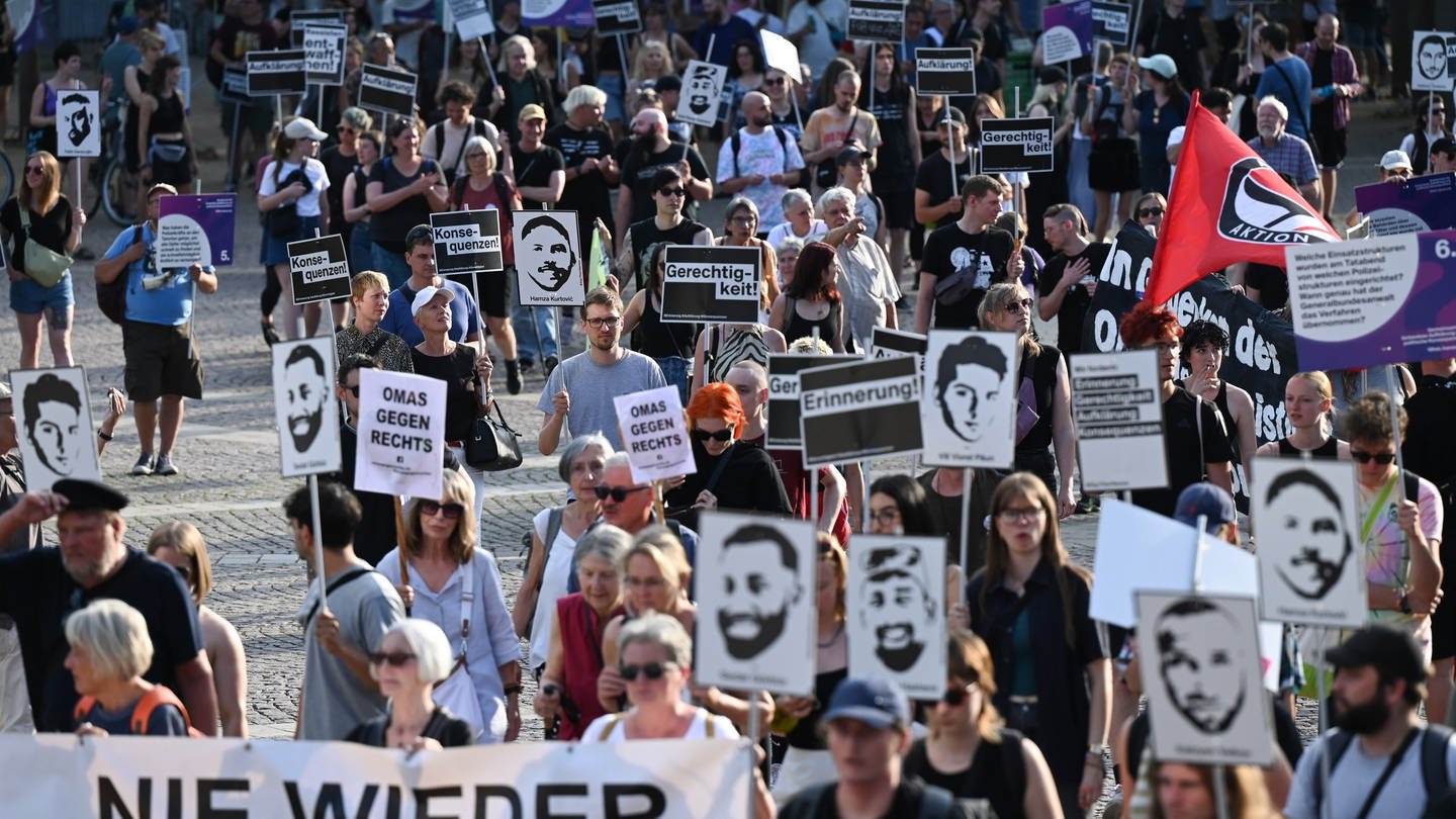 Teilnehmer einer Demo halten im Anschluss an eine Kundgebung für die Opfer des Anschlags von Hanau Plakate mit den Bildern der Opfer. (Foto: dpa Bildfunk, picture alliance/dpa | Arne Dedert)