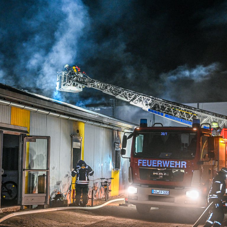 Mitarbeiter der Feuerwehr löschen einen Brand in einer Asylbewerberunterkunft in Nördlingen. (Foto: dpa Bildfunk, picture alliance/dpa | Marius Bulling)