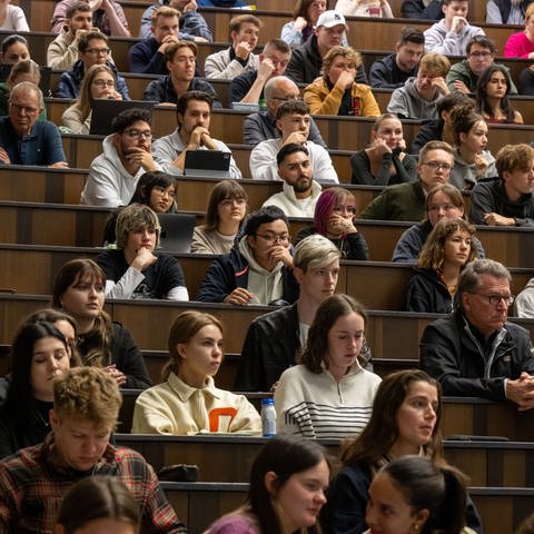 Studierende nehmen an der Einführungsveranstaltung im Audimax der Ludwig-Maximilians-Universität (LMU) teil. (Foto: dpa Bildfunk, picture alliance/dpa | Peter Kneffel)
