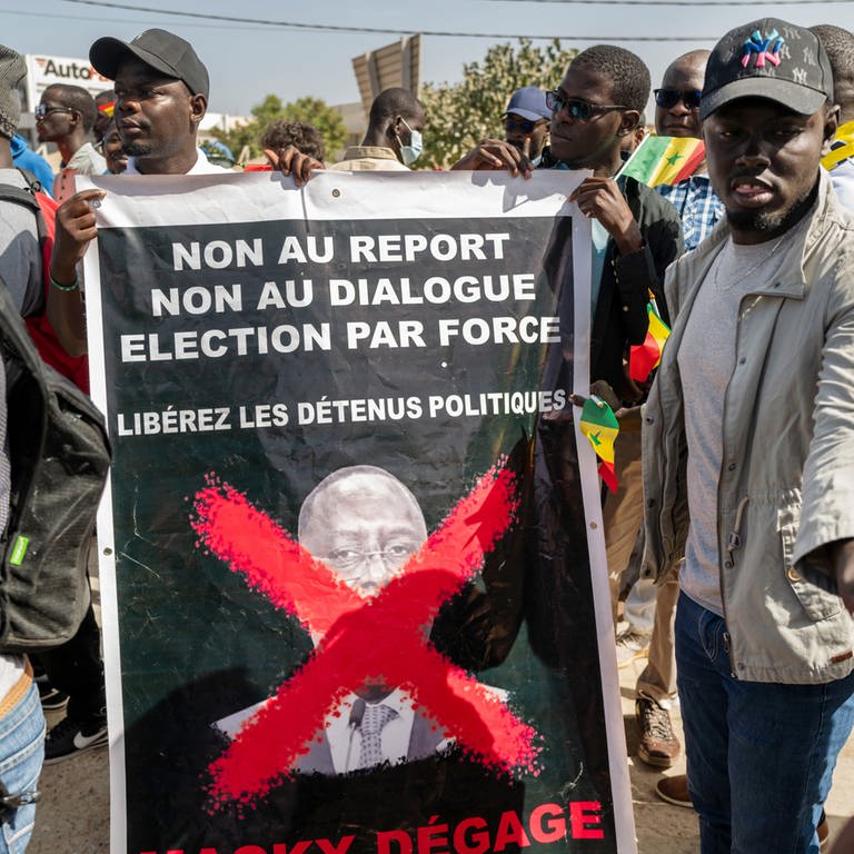 Anhänger des Oppositionskollektivs Aar Sunu Senegal zeigen auf einer Straße in Dakar ein Transparent mit der Aufschrift "Nein zur Verschiebung, nein zum Dialog, Wahl mit Zwang". (Foto: dpa Bildfunk, picture alliance/dpa/AP | Sylvain Cherkaoui)