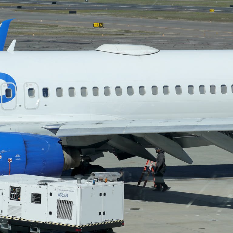 Ein Mitarbeiter des Medford Jet Centers geht unter einer Boeing 737-824 von United Airlines, die auf dem Rogue Valley International-Medford Airport aus San Francisco gelandet ist. Eine Passagiermaschine von United Airlines hat am Freitag im Flug eine Abdeckung an ihrem Rumpf verloren.