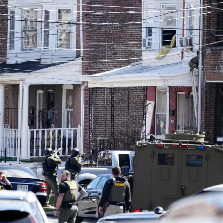 Polizisten umstellen ein Haus. Ein Verdächtiger hatte sich in dem Haus verbarrikadiert und Geiseln genommen, nachdem er in einem Vorort von Philadelphia drei Menschen erschossen hatte. (Foto: dpa Bildfunk, picture alliance/dpa/AP | Matt Rourke)