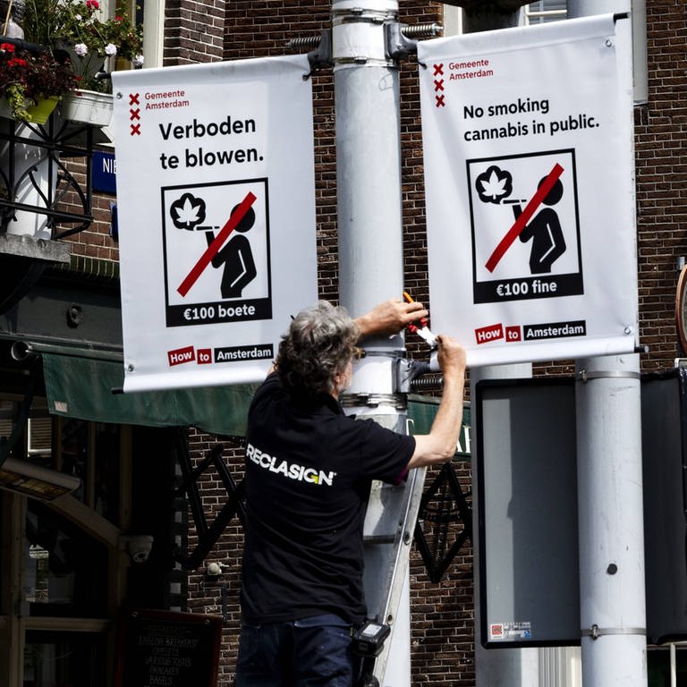 Mitarbeiter der Stadt hängt "Kiffen verboten"-Schilder auf