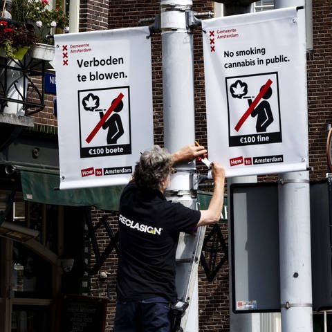 Mitarbeiter der Stadt hängt "Kiffen verboten"-Schilder auf (Foto: IMAGO, IMAGO / ANP)