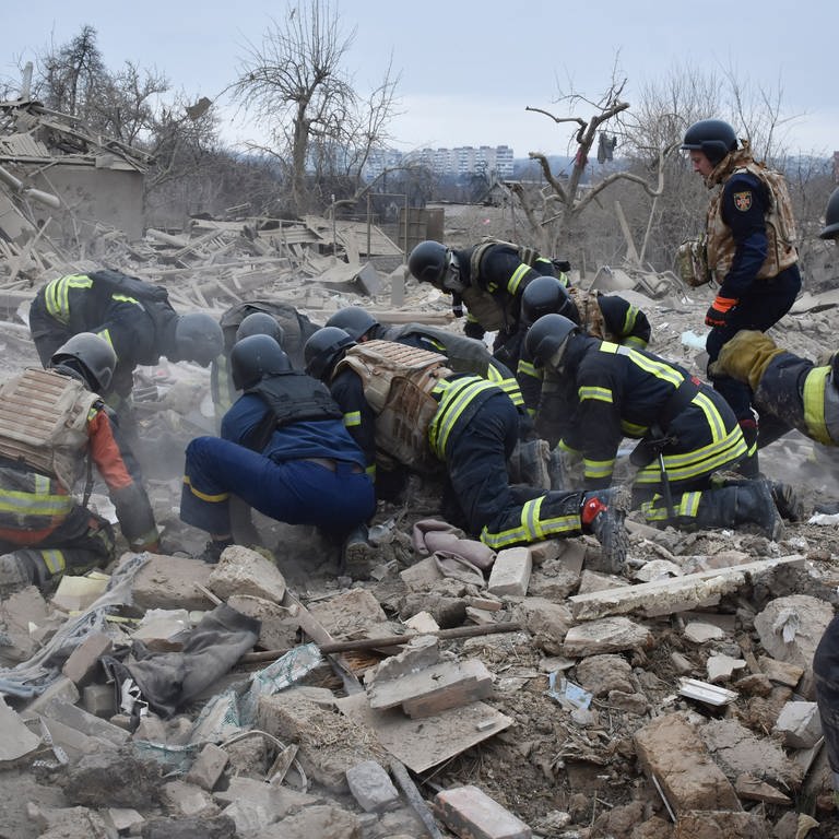 Ukrainische Rettungskräfte räumen die Trümmer am Ort eines russischen Luftangriffs. Russland hat die Ukraine mit einem großflächigen Raketenangriff überzogen.