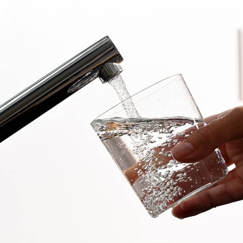 ILLUSTRATION - Eine Hand hält ein Wasserglas unter einen Wasserhahn. (Foto: dpa Bildfunk, picture alliance/dpa | Bernd Weißbrod)