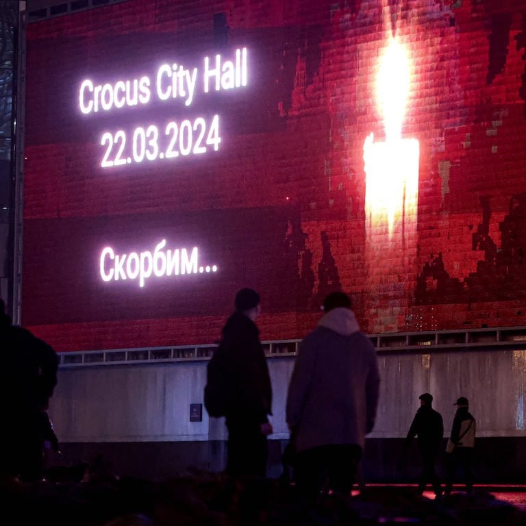 Eine Kerze leuchtet auf einem Bildschirm für die Opfer des Anschlags auf eine Konzerthalle in der Nähe von Moskau.