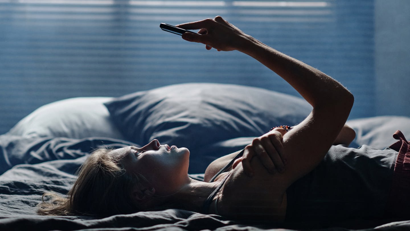 Mädchen liegt im Bett mit Handy (Foto: IMAGO, IMAGO / Pond5 Images)