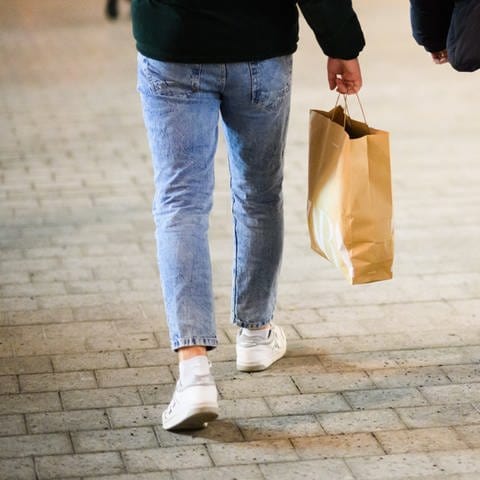 Zwei Jungs laufen mit Einkaufstaschen durch die Innenstadt. - In Mannheim kann man vielleicht ab Sommer mit Krypto im Supermarkt bezahlen.
