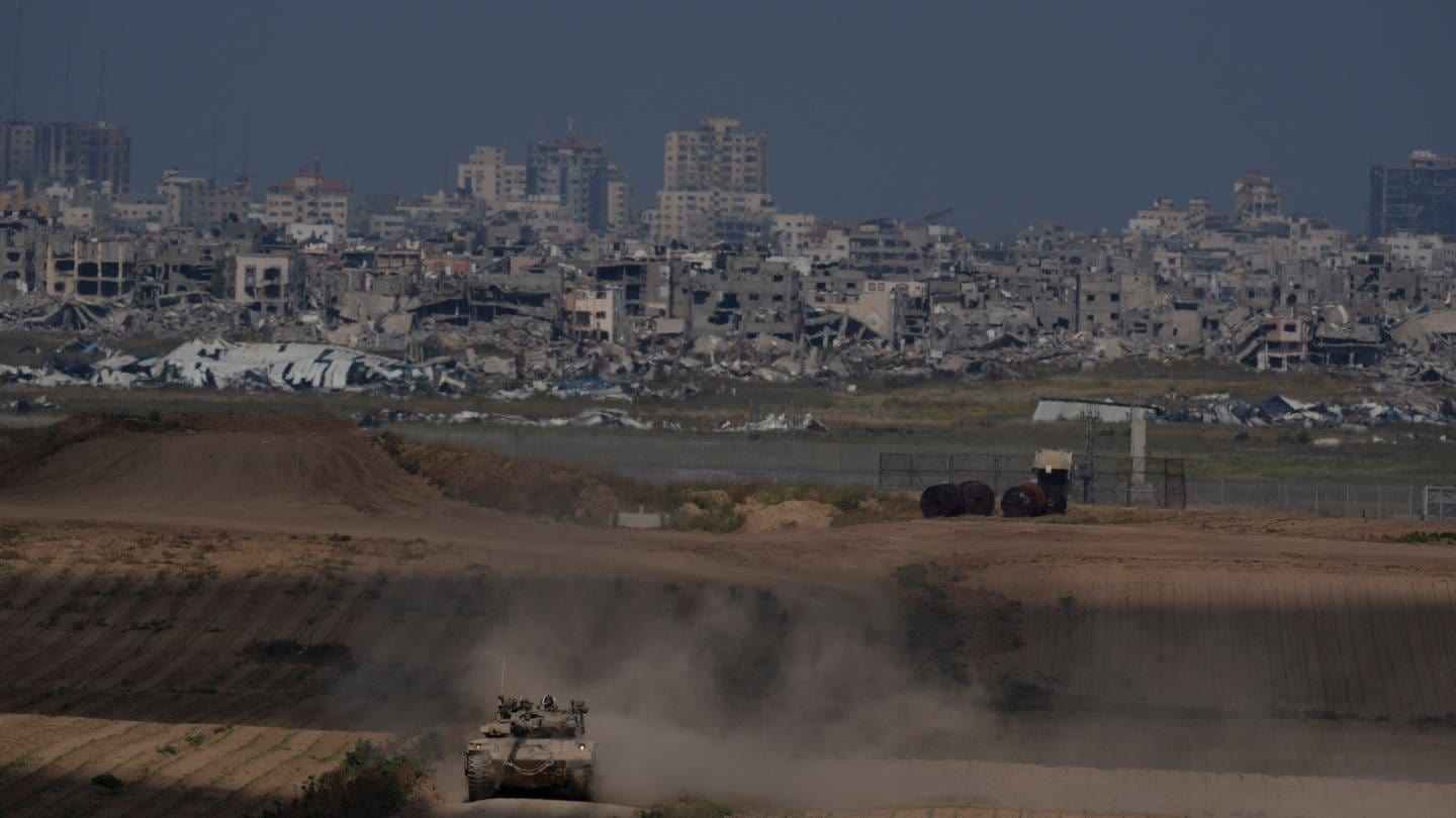 Israelische Soldaten bewegen sich auf einem Panzer nahe der Grenze zwischen Israel und Gaza. - Heute wird in Kairo und Riad über eine mögliche Waffenruhe und Geiselfreilassung verhandelt. (Foto: dpa Bildfunk, picture alliance/dpa/AP | Leo Correa)