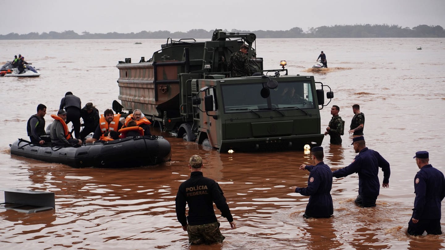 Brasilianische Soldaten und Bundespolizisten evakuieren Bewohner aus einem von schweren Regenfällen überfluteten Gebiet. Bei Überschwemmungen nach tagelangem Regen ist die Zahl der Toten im Süden Brasiliens weiter gestiegen. (Foto: dpa Bildfunk, picture alliance/dpa/AP | Carlos Macedo)