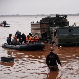 Brasilianische Soldaten und Bundespolizisten evakuieren Bewohner aus einem von schweren Regenfällen überfluteten Gebiet. Bei Überschwemmungen nach tagelangem Regen ist die Zahl der Toten im Süden Brasiliens weiter gestiegen. (Foto: dpa Bildfunk, picture alliance/dpa/AP | Carlos Macedo)