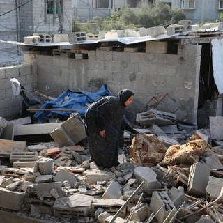 Eine Frau in Rafah sammel Gegenstände auf, nachdem das Gebäude von der israelischen Armee getroffen wurde.
