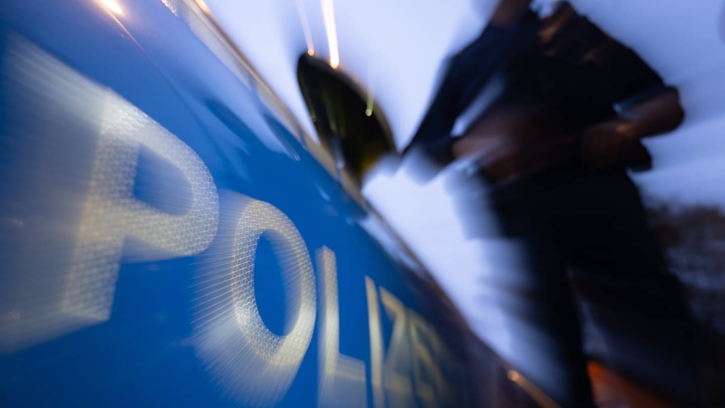 Eine Polizistin steht neben einem Polizeifahrzeug (Symbolbild) - Mann in Berlin gestorben: War es ein Drive-by-Shooting?! (Foto: dpa Bildfunk, picture alliance/dpa | Marijan Murat)