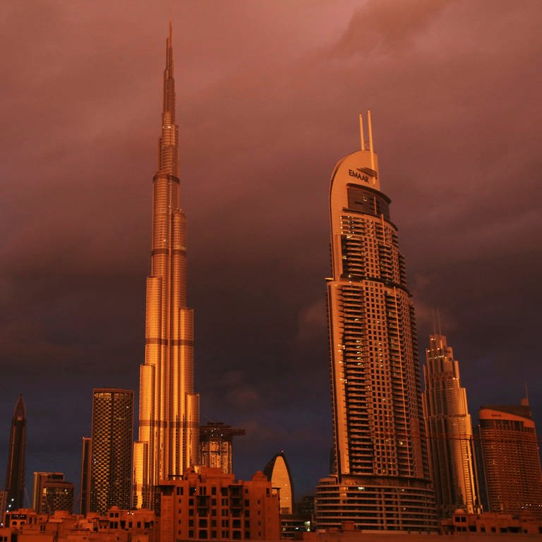 Vereinigte Arabische Emirate, Dubai: Der Burj Khalifa, das höchste Gebäude der Welt, wird während eines Regenschauers von der Sonne angestrahlt.