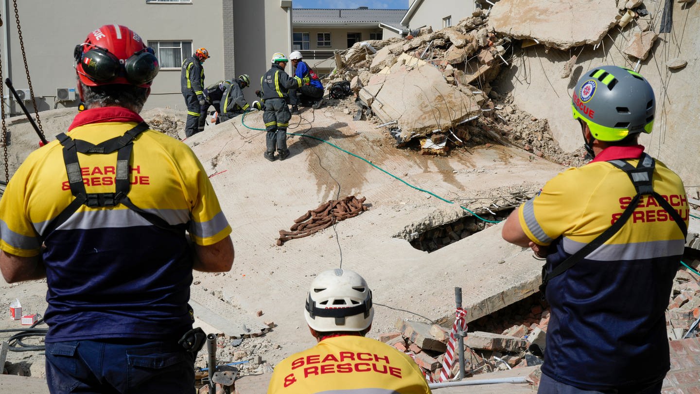 Rettungskräfte durchsuchen die Einsturzstelle eines Gebäudes in George. (Foto: dpa Bildfunk, picture alliance/dpa/AP | Jerome Delay)
