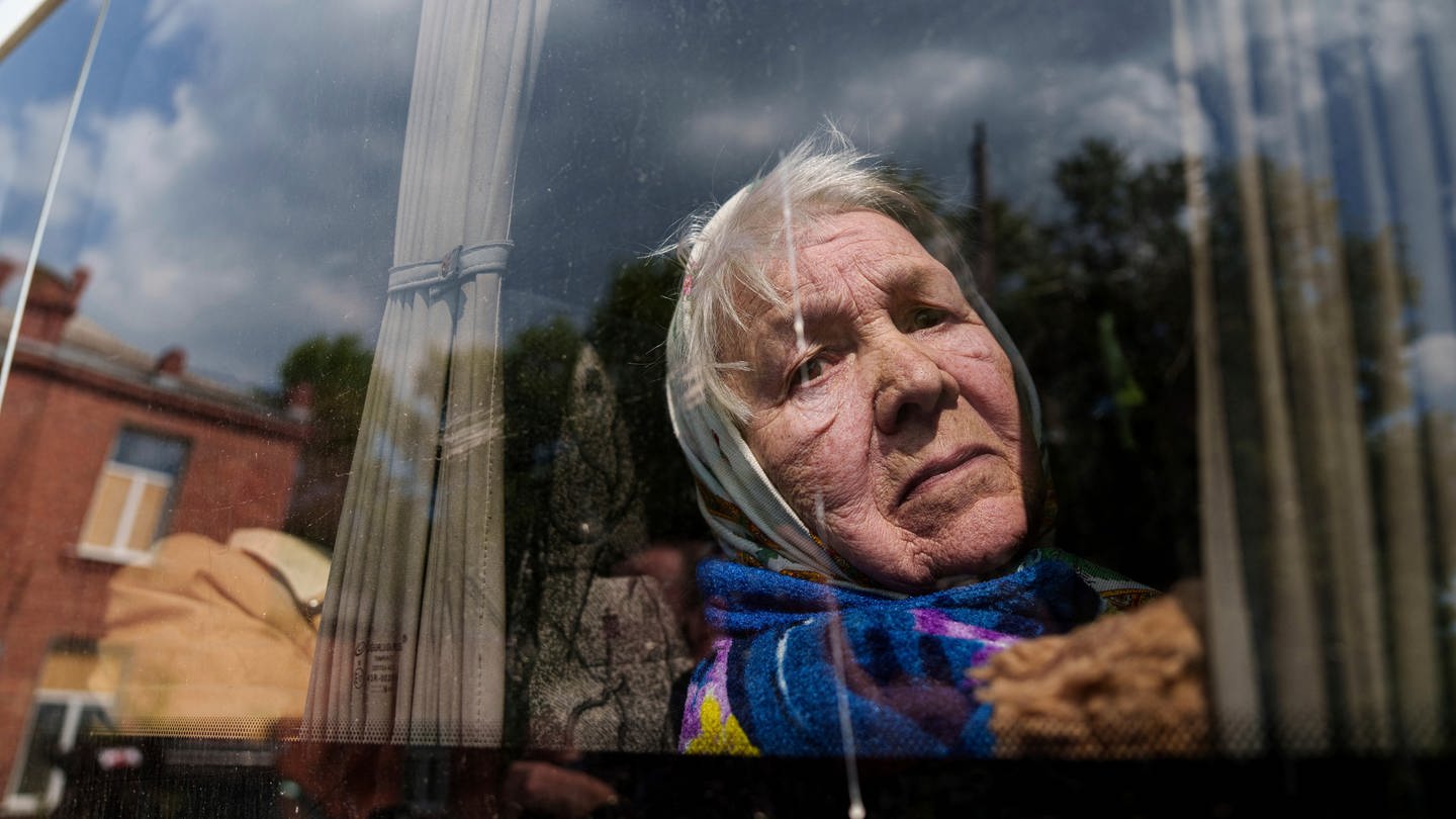 Die 85-Jährige Liudmila blickt durch das Fenster eines Busses, nachdem sie aus Wowtschansk evakuiert wurde. (Foto: dpa Bildfunk, picture alliance/dpa/AP | Evgeniy Maloletka)