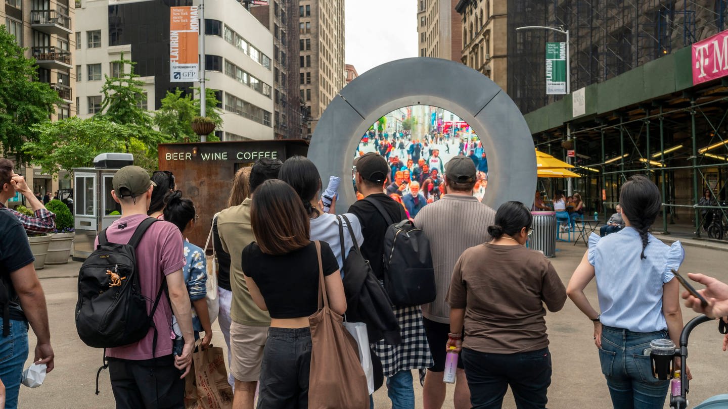 Vor einem Portal in New York stehen mehrere Menschen. (Foto: IMAGO, IMAGO / Levine-Roberts)