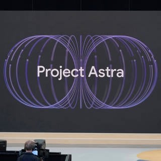 Demis Hassabis (r), CEO von DeepMind Technologies, spricht auf einer Google IO-Veranstaltung über den KI-Sprachassistenten "Project Astra"; dessen Name ist groß auf einer Projektion sichtbar