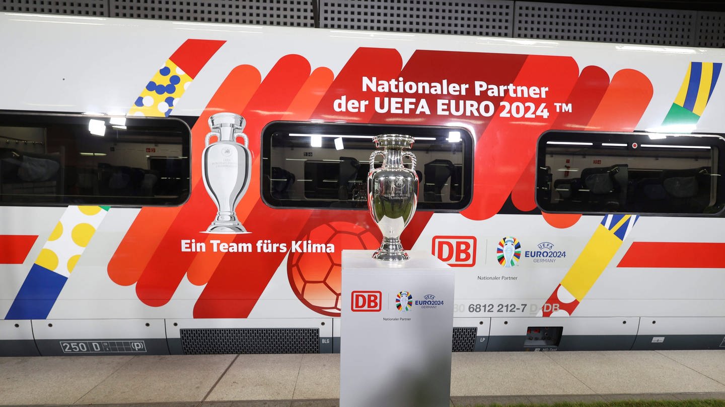 Bei der Bekanntgabe der Partnerschaft zwischen Deutscher Bahn (DB) und der UEFA zur Europameisterschaft 2024 wird der originale EM-Pokal und ein entsprechend gestalteter ICE vorgestellt. (Foto: dpa Bildfunk, picture alliance/dpa | Jörg Carstensen)