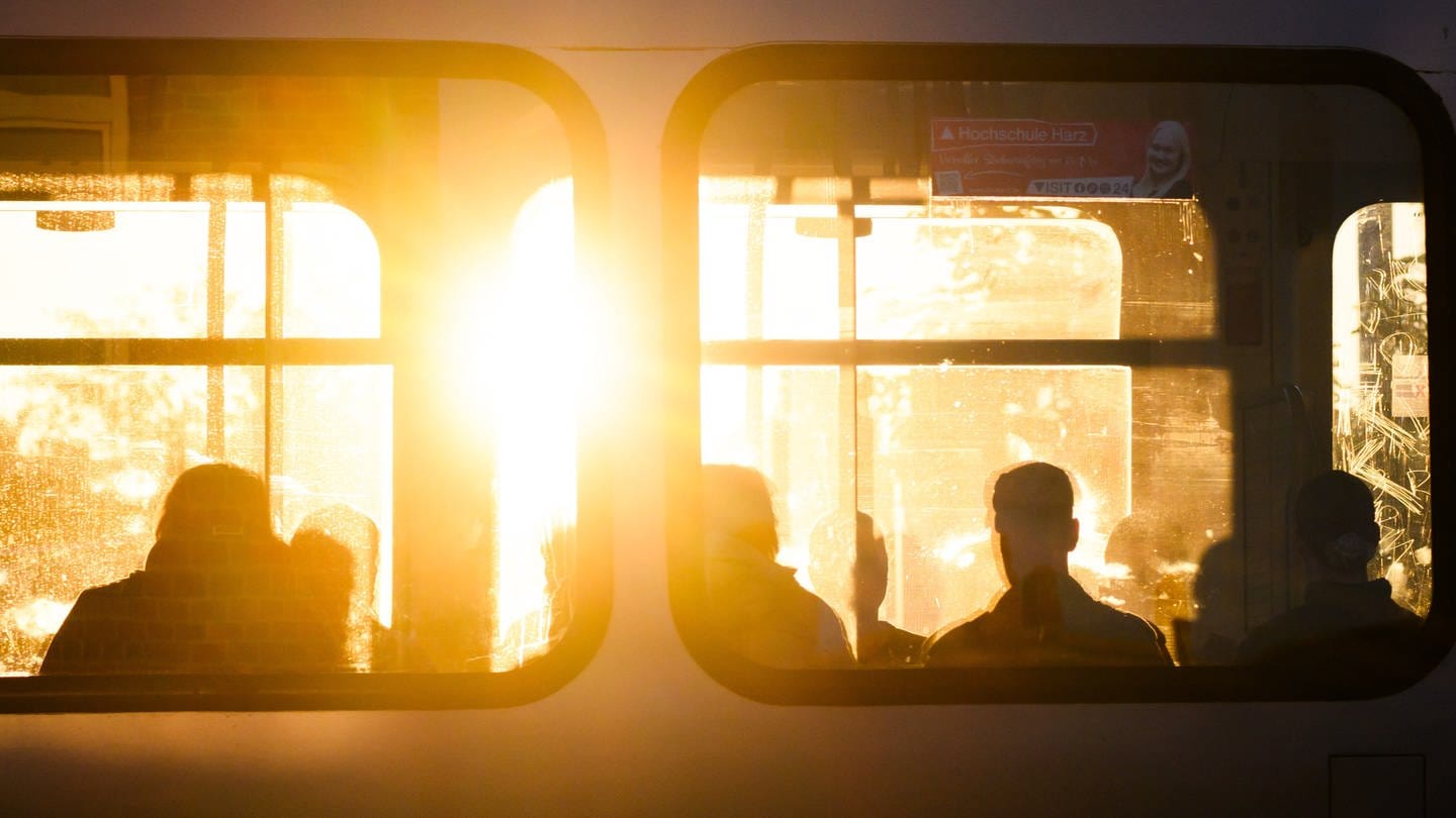 Fahrgäste sitzen bei Sonnenaufgang in einer Stadtbahn der hannoverschen Verkehrsbetriebe uestra. (Foto: dpa Bildfunk, picture alliance/dpa | Julian Stratenschulte)
