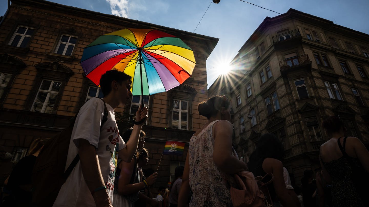Ein Mann nimmt mit einem regenbogenfarbenen Regenschirm an der Pride-Parade in Budapest teil. (Foto: dpa Bildfunk, picture alliance/dpa | Marton Monus)