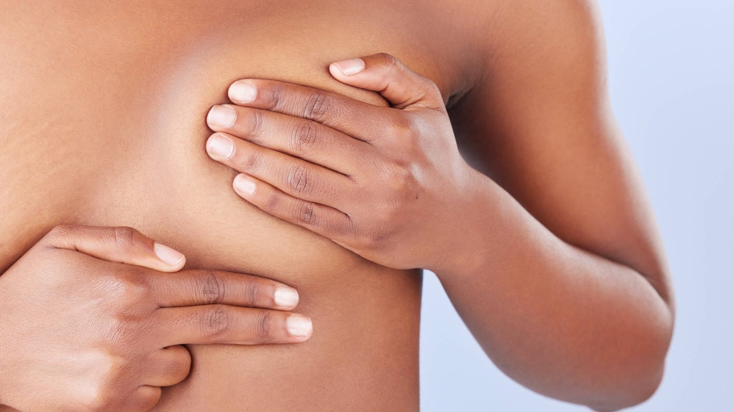 SYMBOLBILD: Eine Frau untersucht ihre Brust, ob sie Knoten findet, die auf Brustkrebs hindeuten können. (Foto: IMAGO, IMAGO / Zoonar)