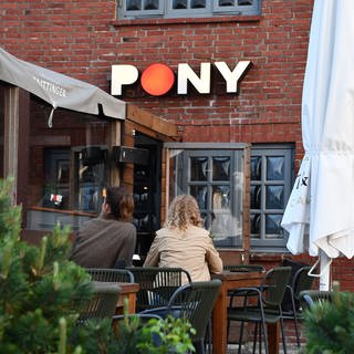 Zwei Frauen sitzen auf der Terrasse des Club „Pony“ in Kampen (Sylt). Hier hatten Party-Gäste zu Pfingsten rassistische Lieder gegrölt.