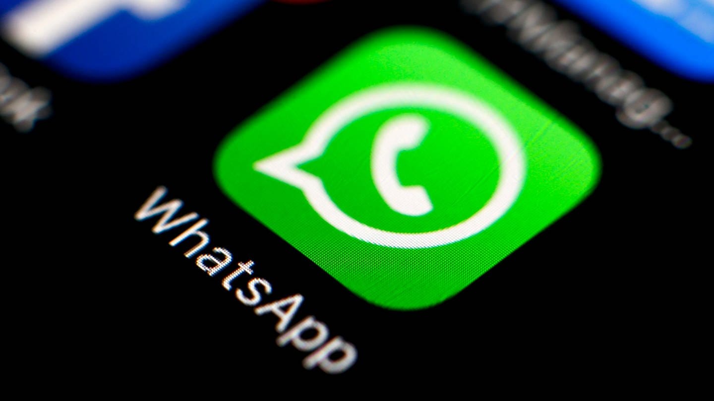 Das Icon des Messengerdienstes WhatsApp und der Online-Plattform Facebook sind auf einem Smartphone zu sehen.