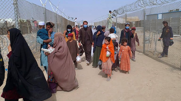 Menschen aus Afghanistan überqueren einen mit Stacheldrahtzäunen gesicherten Grenzübergang zu Pakistan. (Foto: dpa Bildfunk, picture alliance/dpa/AP | -)