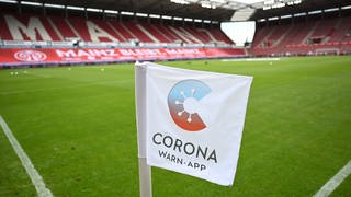 Opel Arena: Eine Eckflagge mit dem Logo der deutschen Corona-Warn-App steht am Spielfeldrand. (Foto: dpa Bildfunk, picture alliance/dpa | Arne Dedert)