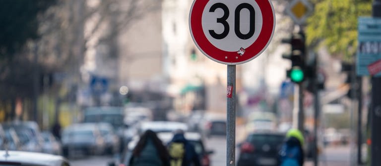 Auto- und Radfahrer passieren ein Verkehrschild in einer Zone mit 30 Kilometern Geschwindigkeitsbeschränkung (Foto: dpa Bildfunk, Picture Alliance)