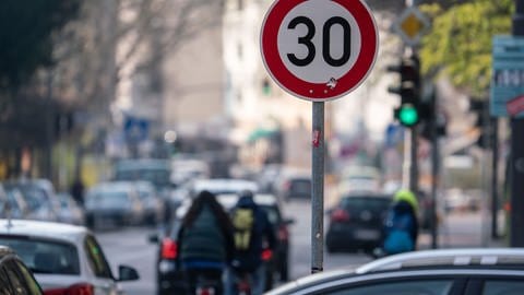 Auto- und Radfahrer passieren ein Verkehrschild in einer Zone mit 30 Kilometern Geschwindigkeitsbeschränkung (Foto: dpa Bildfunk, Picture Alliance)