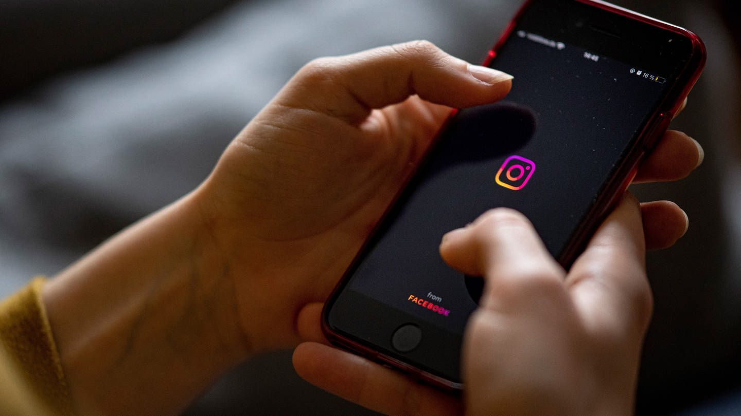 Auf dem Bildschirm eines Smartphones sieht man das Logo der App Instagram.
