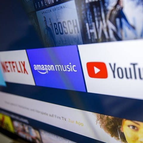 Symbolfoto: Die Logos der Streaming Dienste Amazon Prime Video, Netflix, amazon music und youtube sind auf einem Fernseher zu sehen.