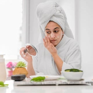 (Symbolbild) Eine Frau trägt Gesichtscreme auf.